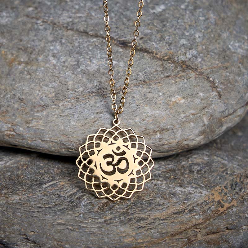 Gold Om mandala lotus necklace on gray stone, spiritual pendant