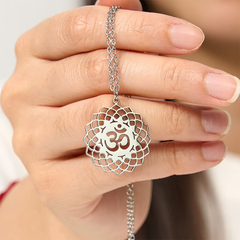 Silver Om lotus pendant held in hand, spiritual yoga necklace