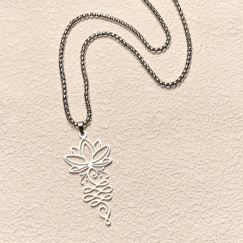 Lotus Vines Chakra Necklace – Overhead flat lay of silver lotus vine pendant, stainless steel necklace