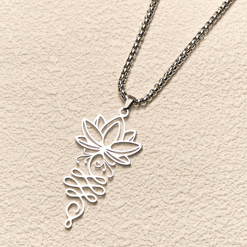 Lotus Vines Chakra Necklace – Angled view of silver lotus-unalome pendant on neutral surface, spiritual necklace