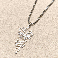 Lotus Vines Chakra Necklace – Angled view of silver lotus-unalome pendant on neutral surface, spiritual necklace