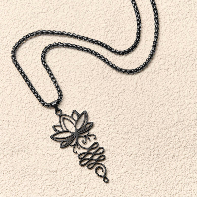 Lotus Vines Chakra Necklace – Angled black lotus pendant on textured neutral background, chakra jewelry