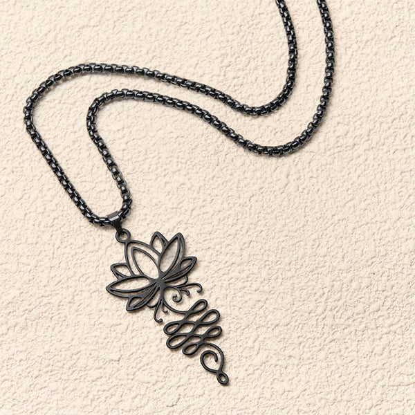 Lotus Vines Chakra Necklace – Angled black lotus pendant on textured neutral background, chakra jewelry