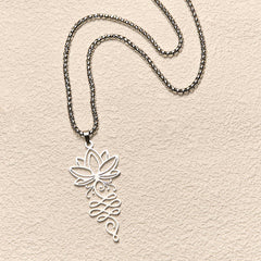Lotus Vines Chakra Necklace – Overhead flat lay of silver lotus vine pendant, stainless steel necklace