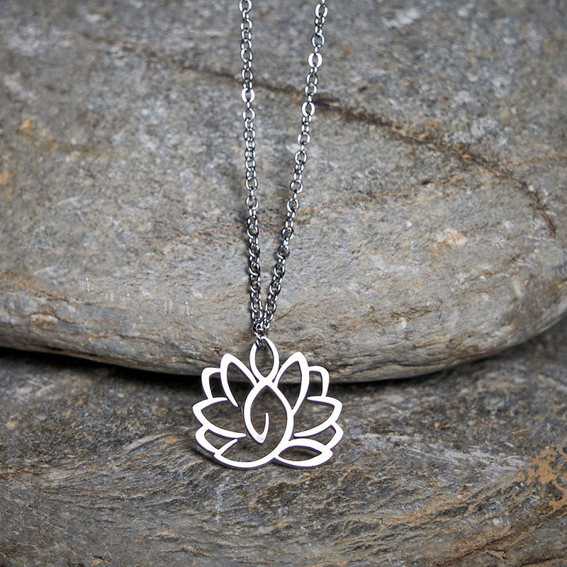 Hollow Lotus Necklace – Silver lotus pendant hanging over natural gray stones, purity spiritual jewelry