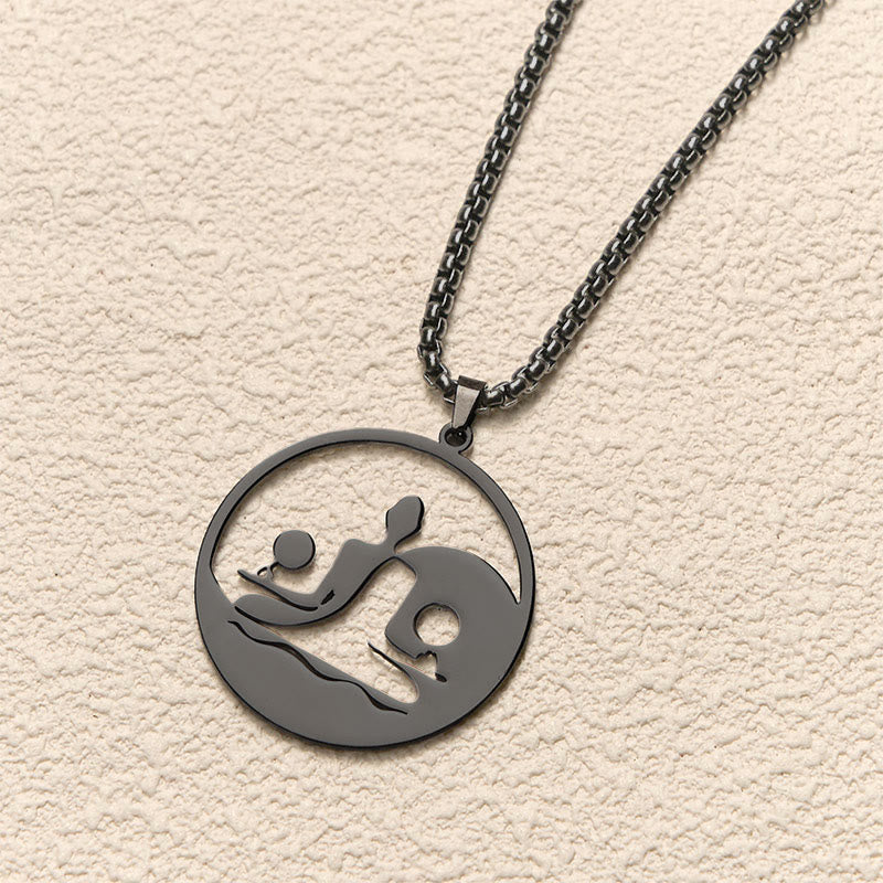 Yin Yang Buddha Stainless Steel Necklace – angled cream background black Buddha yin yang pendant chain, angled