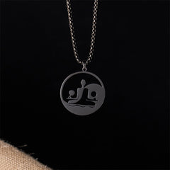 Yin Yang Buddha Stainless Steel Necklace – front black background burlap black Buddha yin yang pendant, dark studio