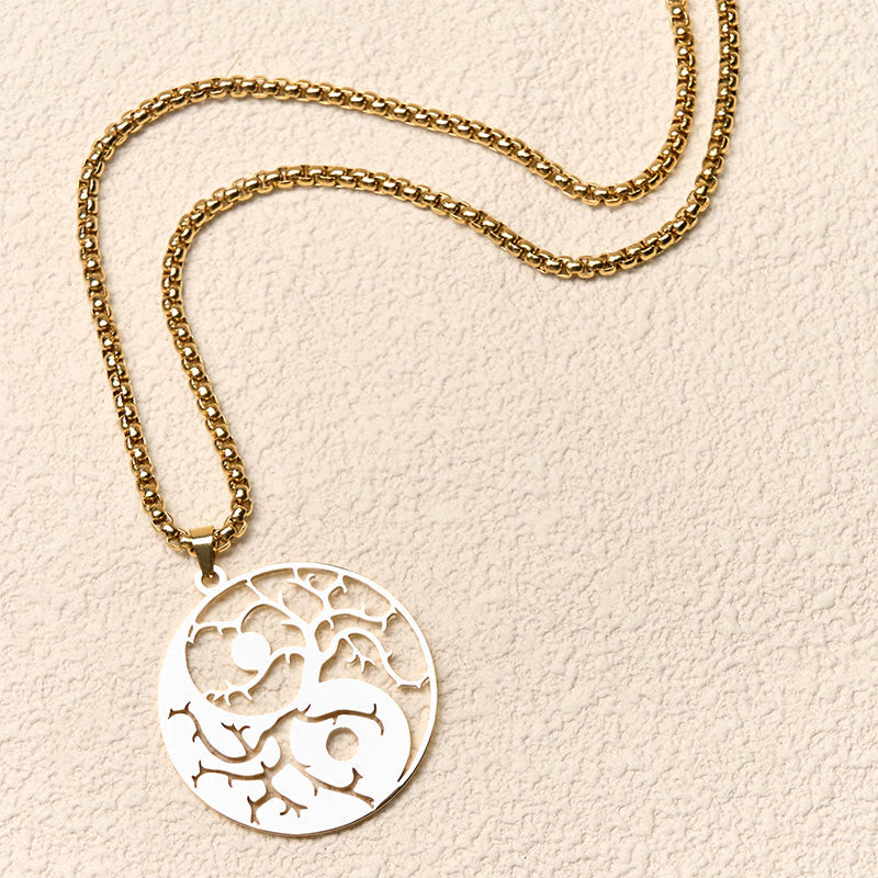 Yin Yang Branches Necklace – Gold pendant top-down on cream surface, yin yang jewelry