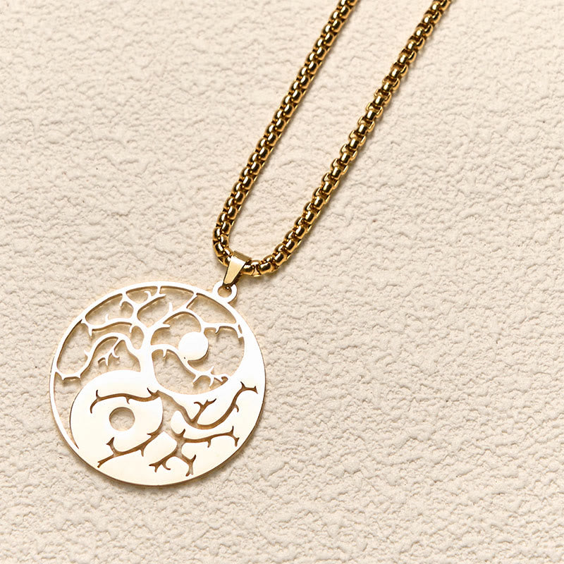 Yin Yang Branches Necklace – Gold pendant flat lay on cream texture, tree of life