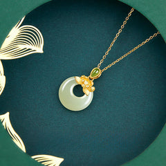 Hetian Jade Lotus Peace Buckle Necklace - flat lay on green velvet pad with gold leaf frame, Luxurious