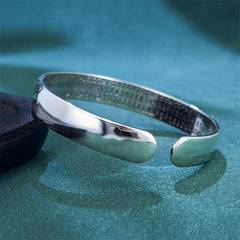 Heart Sutra Koi Fish Copper Bracelet – polished exterior with hammered interior, clean simple band on teal background
