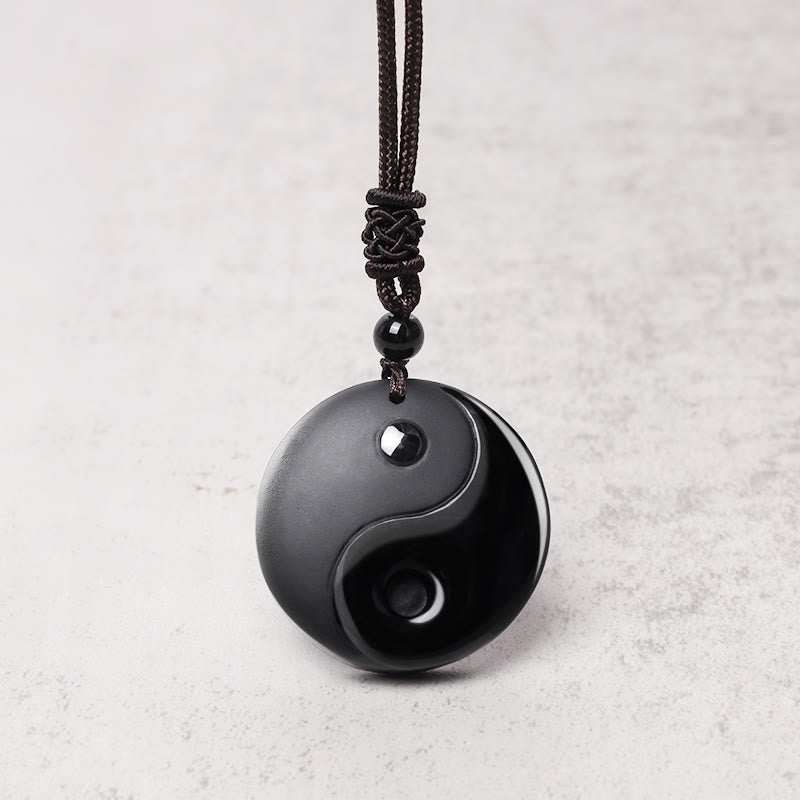 Black Obsidian Yin Yang Necklace – On gray stone background, protection balance necklace