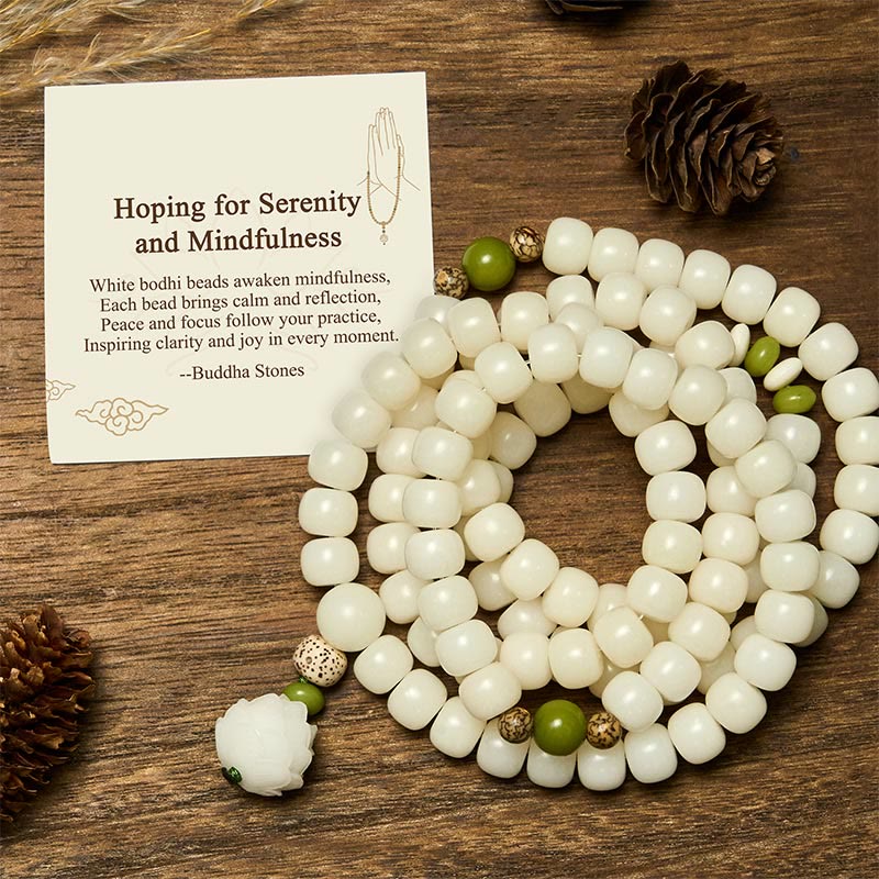 Bodhi Seed Lotus Mala - coiled white prayer beads with green jade accents on wooden table, serene