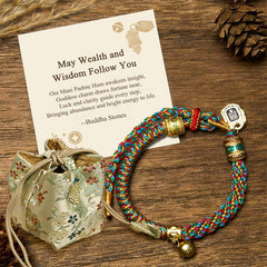 Zakiram Om Mani Padme Hum String Bracelet – braided rope with metal beads and silk pouch on wooden surface, mantra bracelet