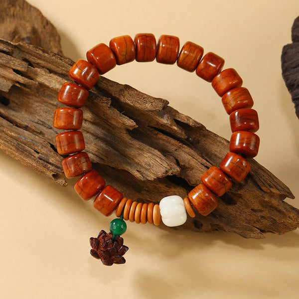 Bone Beads Lotus Peace Buckle Enlightenment Bracelet – draped on driftwood showing lotus pendant detail, organic