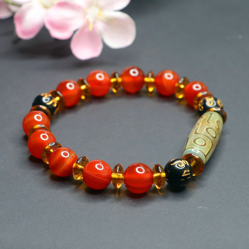 Red Agate Nine-Eye Dzi Bead Bracelet – close-up of orange agate eye beads with amber crystal spacers and floral accent