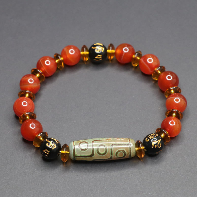Red Agate Nine-Eye Dzi Bead Bracelet – top-down view on gray, warm carnelian beads with cylindrical dzi focal bead Main image