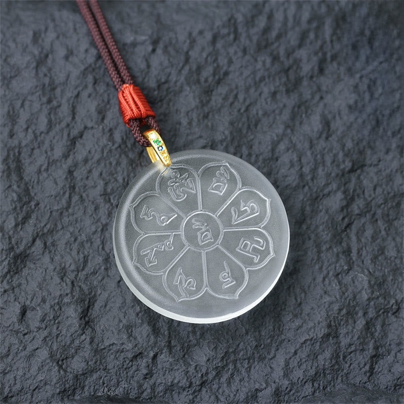 Liuli Crystal Wealth God Mantra Abundance Eight-Petal Necklace – clear liuli pendant with gold clasp on slate, detail shot