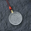 Liuli Crystal Wealth God Mantra Abundance Eight-Petal Necklace – clear liuli pendant with gold clasp on slate, detail shot