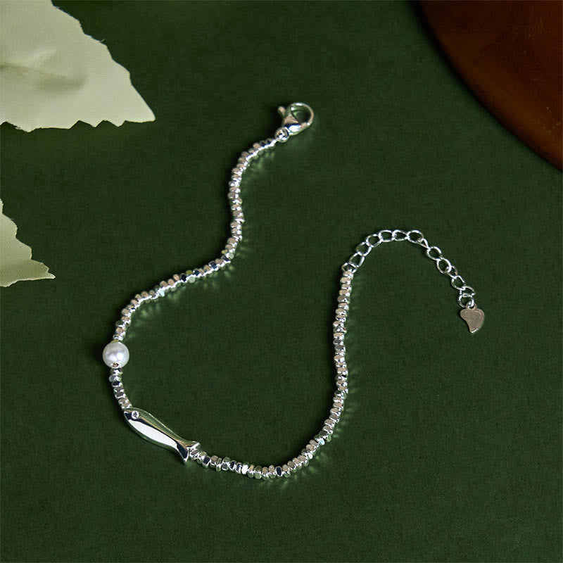Silver Koi Fish Pearl Luck Bracelet – S-curve flat-lay on dark green, koi and pearl with heart tag extender