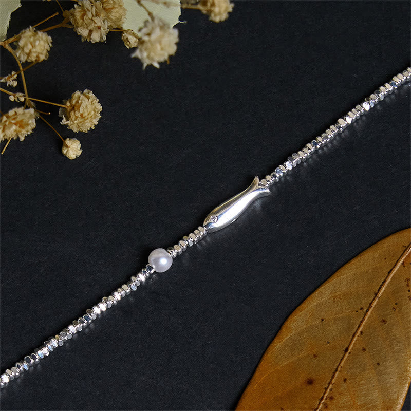 Silver Koi Fish Pearl Luck Bracelet – diagonal shot on black, koi facing left with pearl and baby's breath