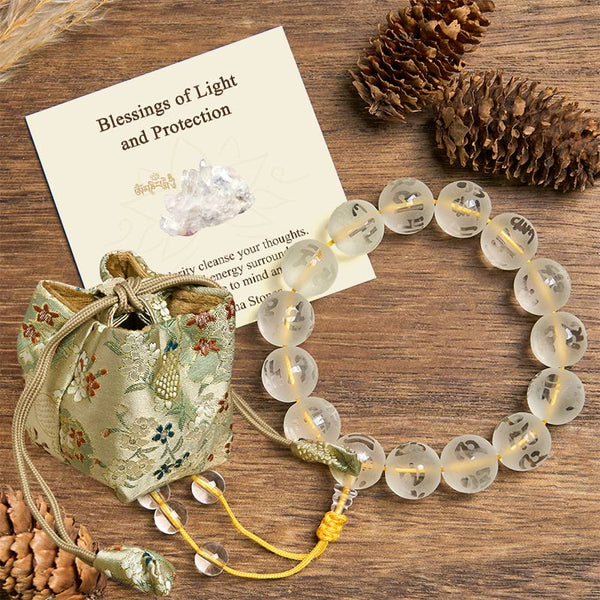 White Crystal Om Mani Padme Hum Bracelet – top-down view with brocade pouch and blessing card