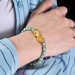 Golden Pi Xiu Charm Jade Prosperity Beaded Bracelet – Wrist model wearing green jade and gold Pi Xiu bracelet, blue shirt