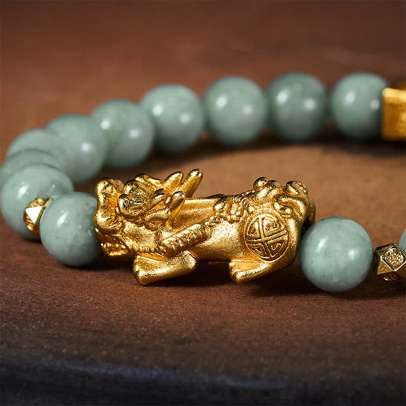 Golden Pi Xiu Charm Jade Prosperity Beaded Bracelet – Close-up of gold Pi Xiu charm with green jade beads on brown surface