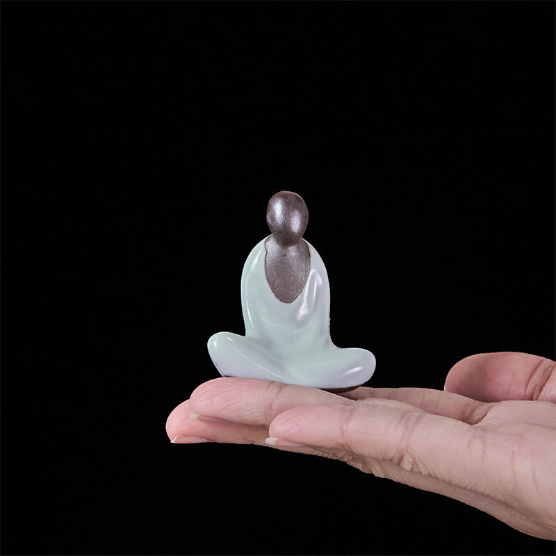 Ceramic Formless Buddha Meditating Statue – resting in palm showing compact size, black backdrop, handheld scale reference
