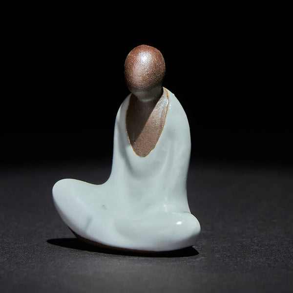 Ceramic Formless Buddha Meditating Statue – front view, white celadon glaze with brown head, dark studio backdrop, zen decor
