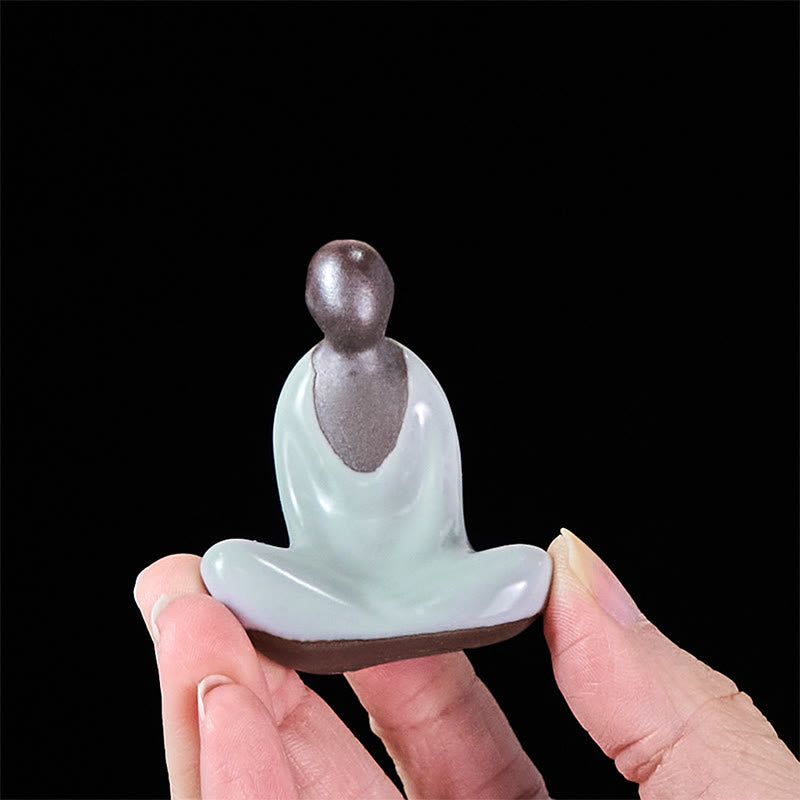 Ceramic Formless Buddha Meditating Statue – held between fingers revealing base detail, miniature ceramic figure, size comparison