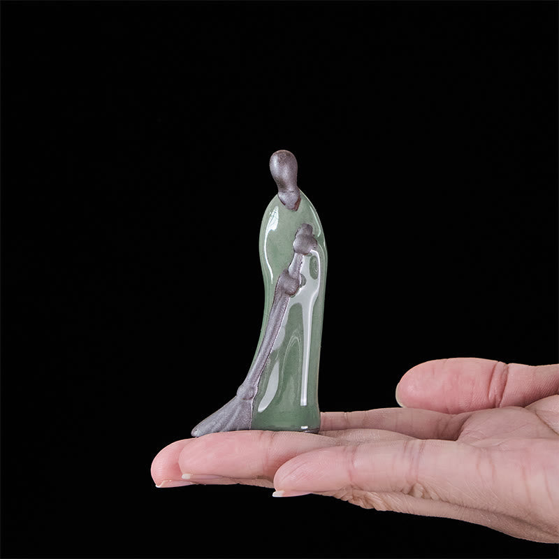 Ceramic Sweeping Monk Buddha Statue – monk held in palm for scale, compact size handheld