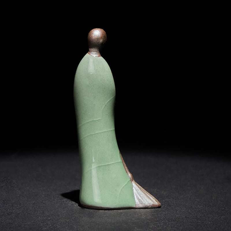Ceramic Sweeping Monk Buddha Statue – celadon monk back view showing robe curves, dark studio