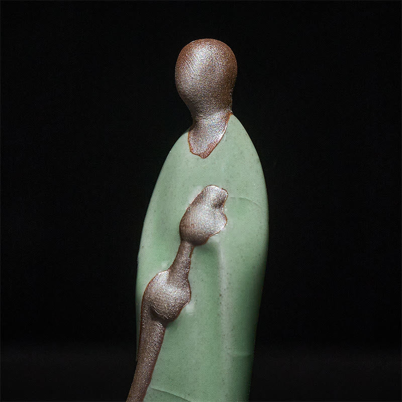 Ceramic Sweeping Monk Buddha Statue – closeup of monk head and broom texture, macro detail