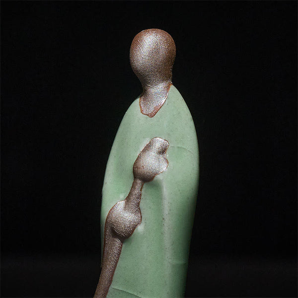 Ceramic Sweeping Monk Buddha Statue – closeup of monk head and broom texture, macro detail