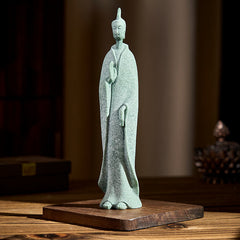 Sandstone Meditation Buddha Standing Statue – front view on wooden table with books and crystal accents, serene ambiance