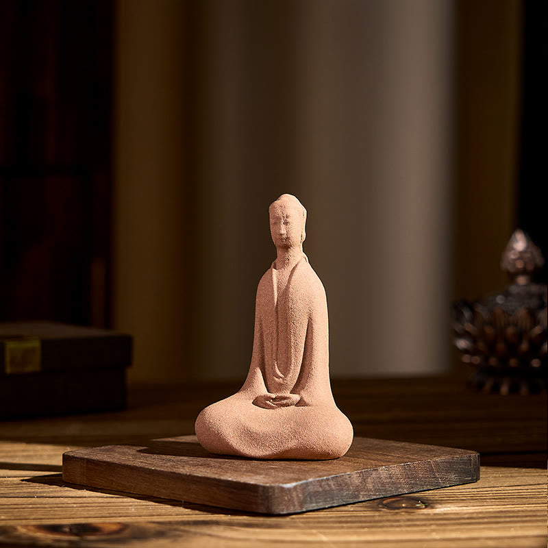 Ceramic Sitting Buddha Prayer Statue – Front on wood with decorative lotus accent in soft light, meditation