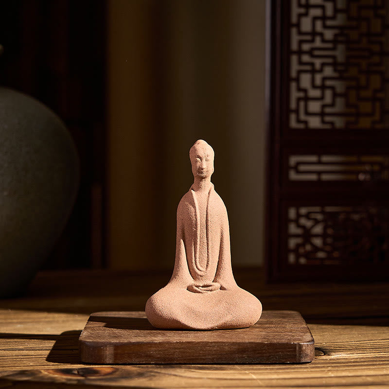 Ceramic Sitting Buddha Prayer Statue – Front angle on wood base with warm lighting and screen, peaceful