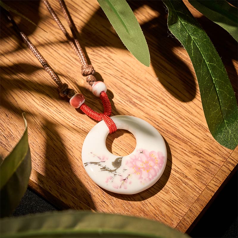 Ceramic Peony & Lotus Pendant – Bird and cherry blossom on white disc with red cord, floral necklace