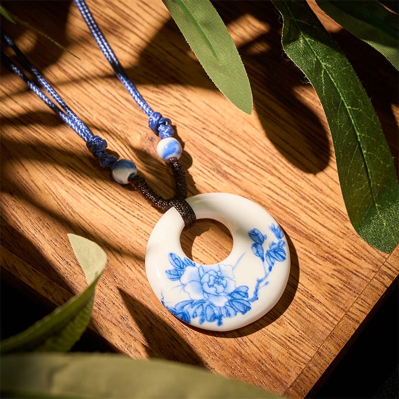 Ceramic Peony & Lotus Pendant – Peony blossom on white ceramic over wood with green leaves, artisan jewelry