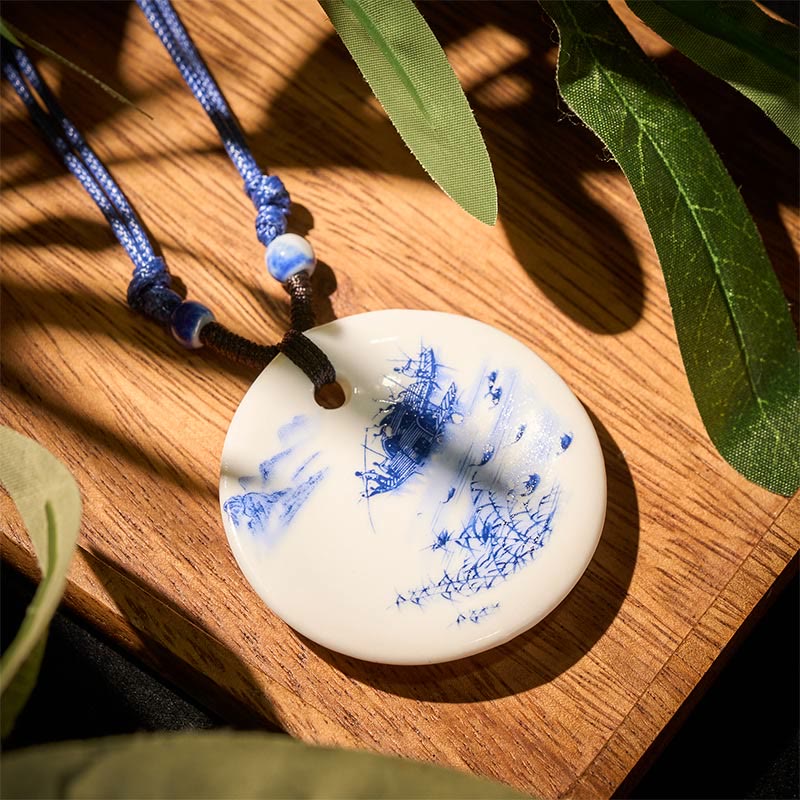 Ceramic Peony & Lotus Pendant – Pagoda landscape on porcelain disc over wood with leaves, artisan pendant