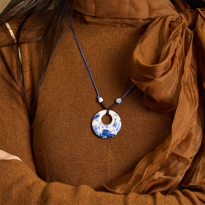 Ceramic Peony & Lotus Pendant – Worn on model with rust sweater and sheer scarf, blue-white necklace