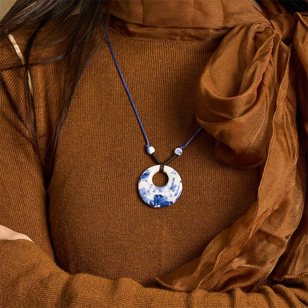 Ceramic Peony & Lotus Pendant – Worn on model with rust sweater and sheer scarf, blue-white necklace