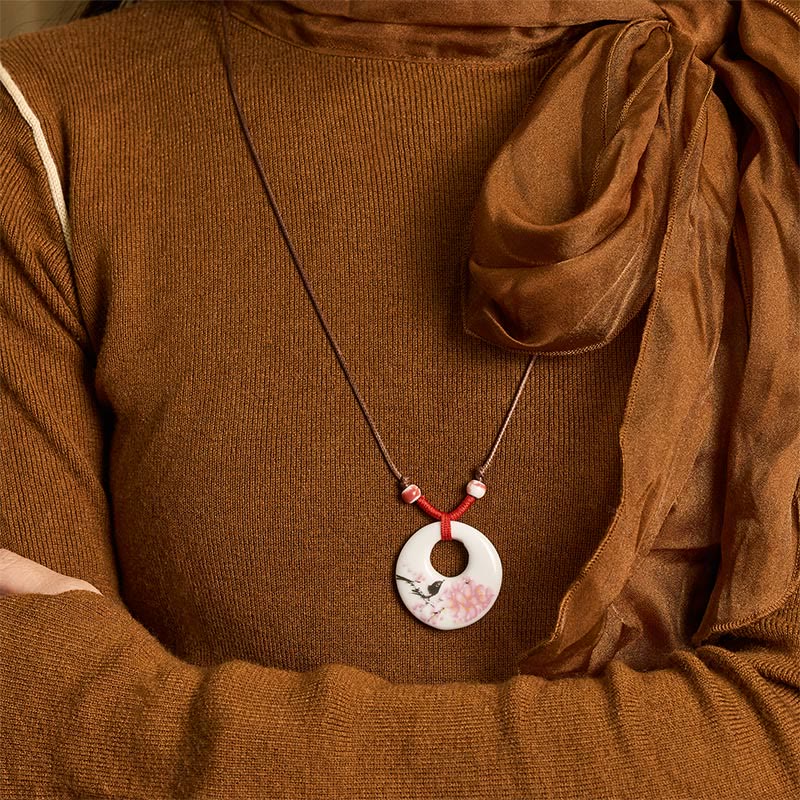 Ceramic Peony & Lotus Pendant – Bird and blossom pendant worn with brown knit on-model, floral necklace