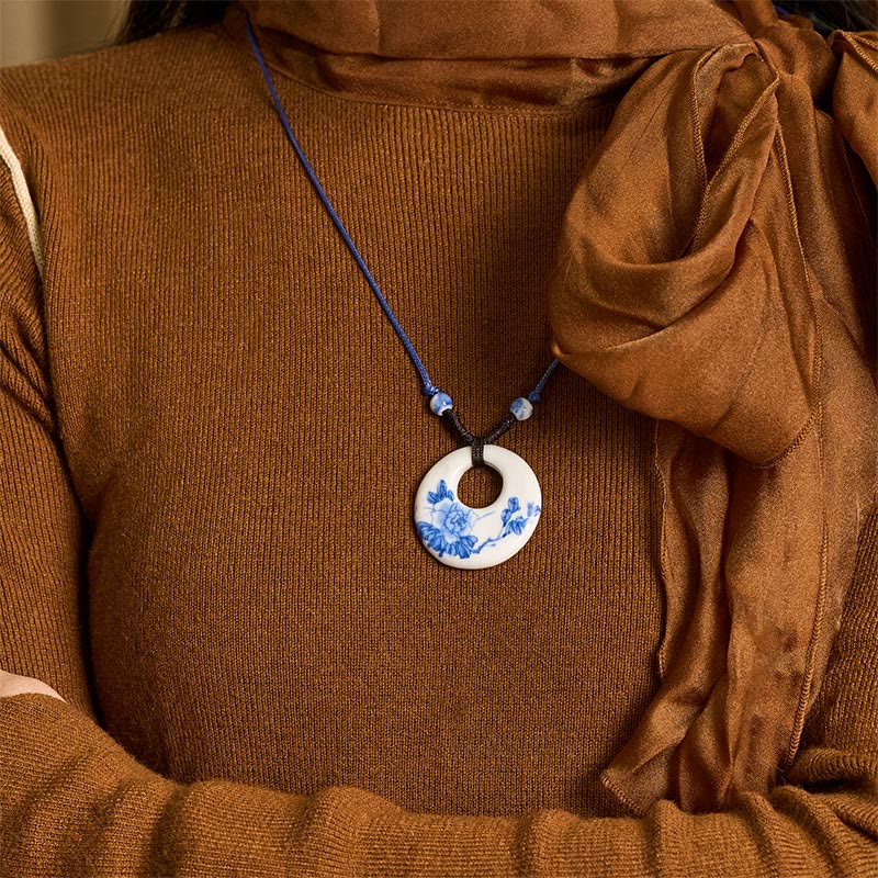 Ceramic Peony & Lotus Pendant – On-model view with brown turtleneck and draped scarf, porcelain jewelry