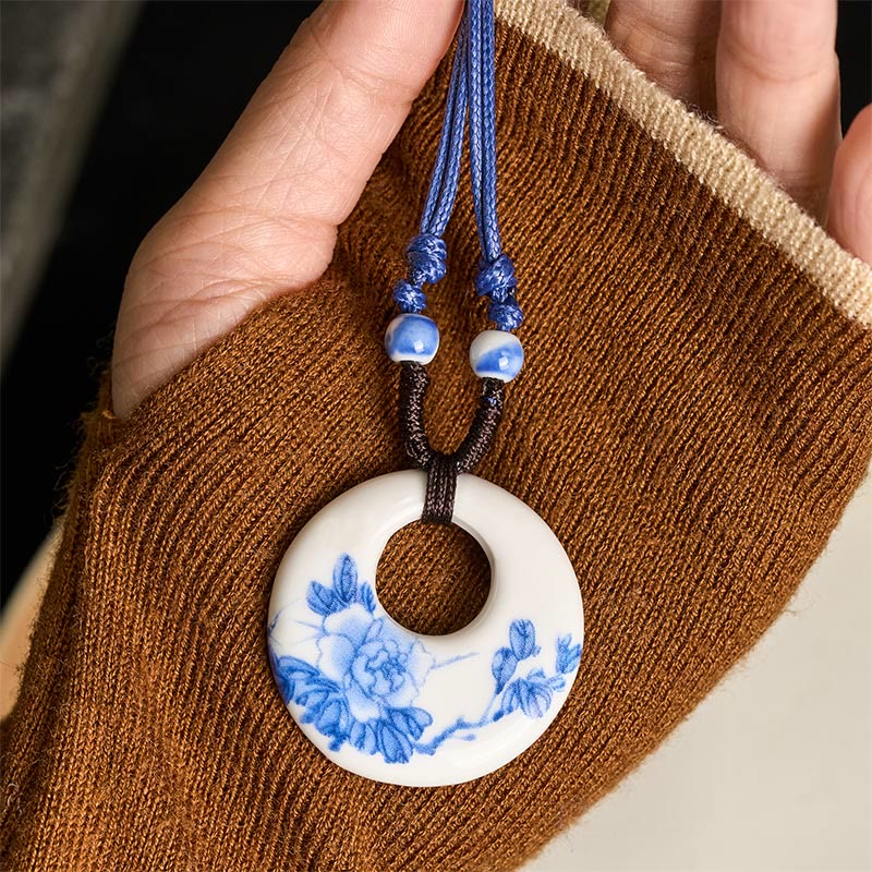 Ceramic Peony & Lotus Pendant – Peony bloom held on woven brown fabric with blue cord, handcrafted necklace