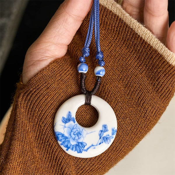 Ceramic Peony & Lotus Pendant – Peony bloom held on woven brown fabric with blue cord, handcrafted necklace