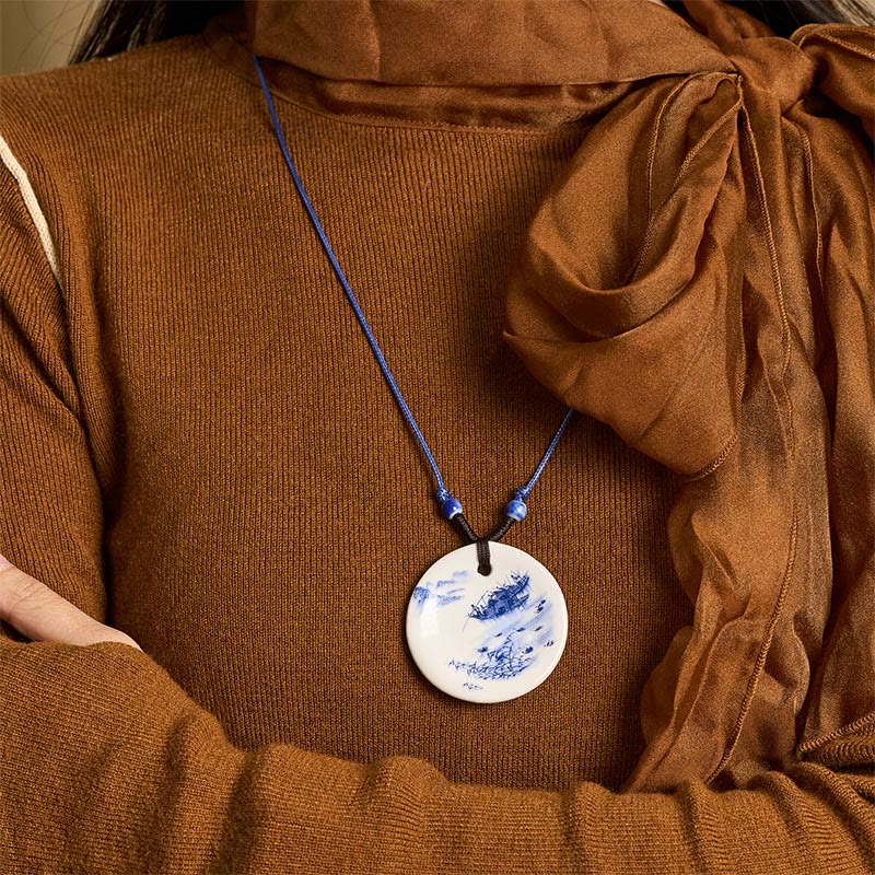 Ceramic Peony & Lotus Pendant – Porcelain landscape disc worn with knit and sheer scarf, on-model necklace