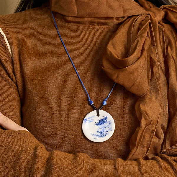 Ceramic Peony & Lotus Pendant – Porcelain landscape disc worn with knit and sheer scarf, on-model necklace