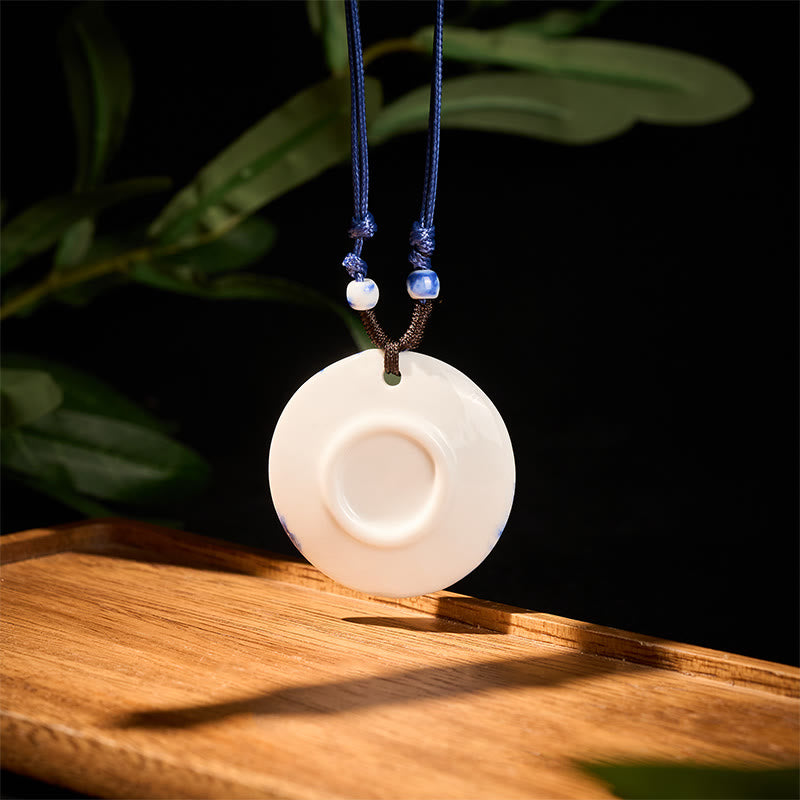 Ceramic Peony & Lotus Pendant – White ceramic disc with recessed center on wood, minimalist necklace